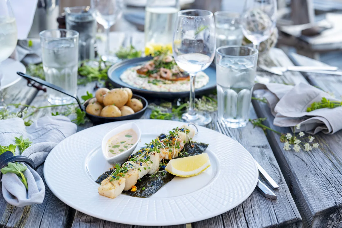 Grillet fisk servert på dekket bord hos Restaurant Nyvågar